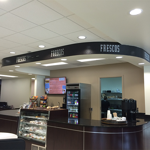 Frescos Signage above cash register. Black-on-Black Background with White Logo.